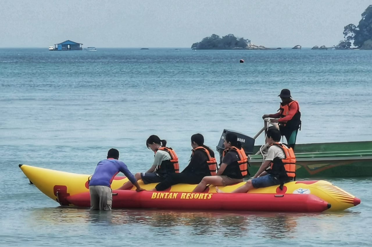 Sejumlah wisawatan berlibur, bermain banana boat di pantai yang ada di kawasan Pariwisata Lagoi, Kabupaten Bintan beberapa waktu lalu. (Dokumen Diskominfo Kepri)